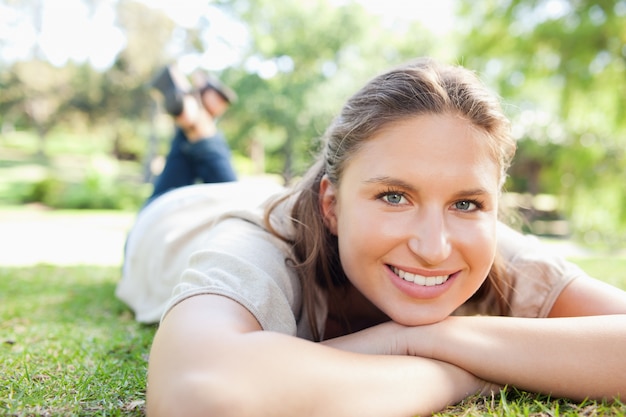 Mulher sorridente deitada no gramado