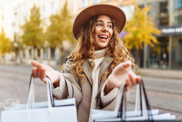 Mulher sorridente depois de fazer compras na rua da cidade Conceito de venda de compras Conceito de compras on-line
