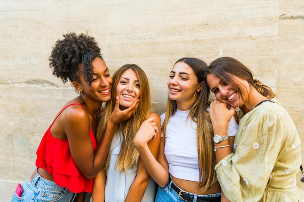 Foto mulher sorridente e alegre de pé contra a parede ao ar livre