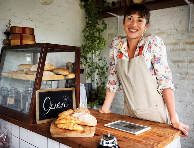 Mulher sorridente, em, a, madeira, cozer, casa, contador, com, tablete digital