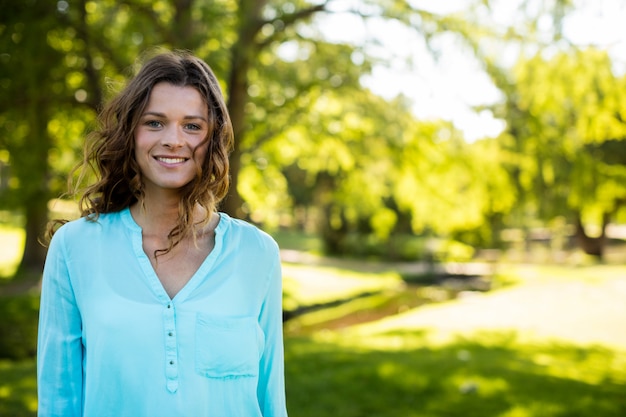 Mulher sorridente em pé no jardim