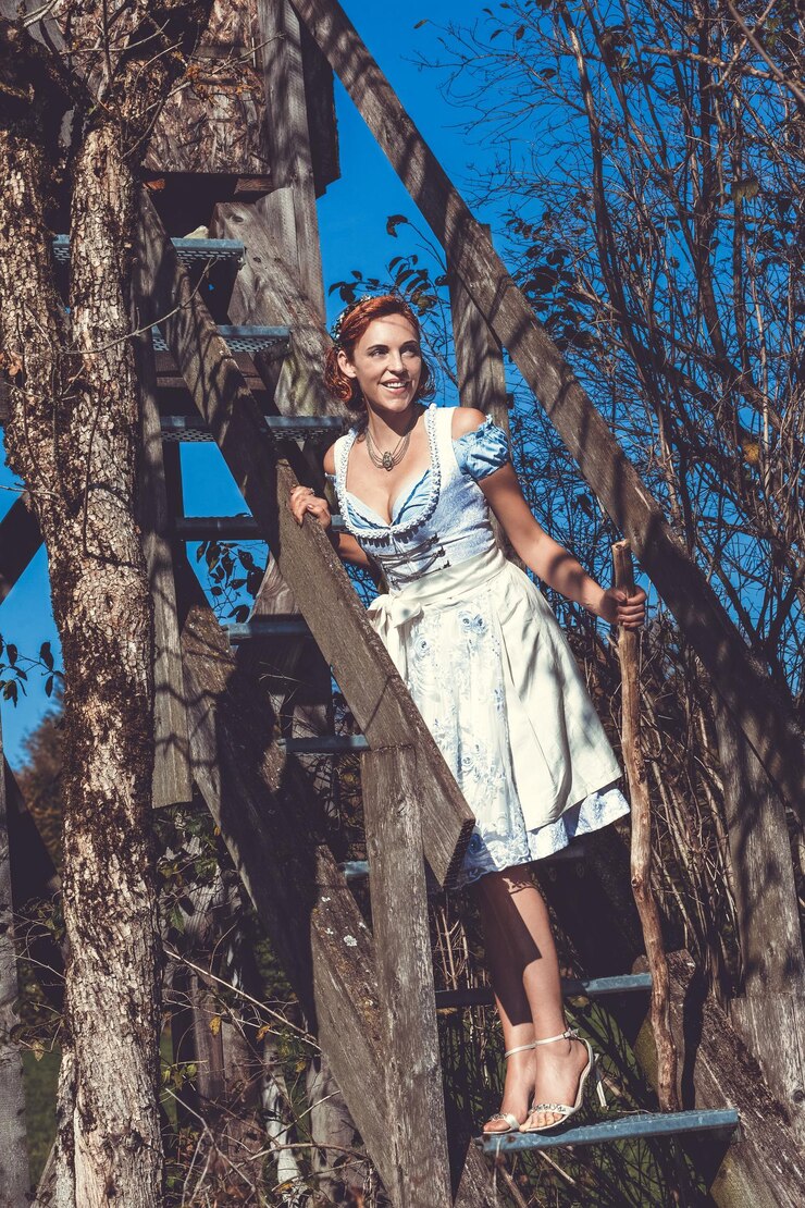 Foto mulher sorridente em roupas tradicionais de pé na escada