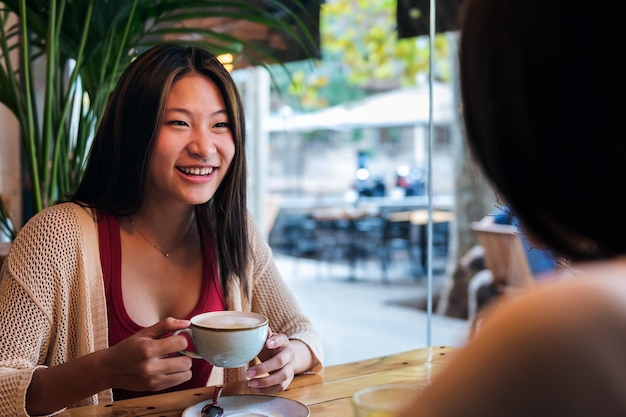 Mulher sorridente em uma cafeteria com um amigo