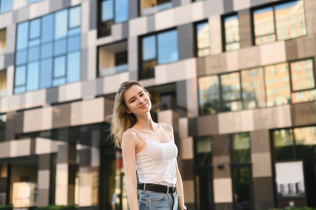 Mulher sorridente em uma camiseta branca e jeans