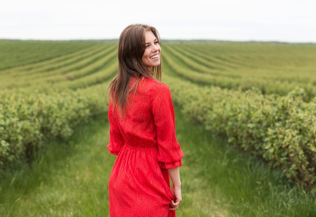 Foto mulher sorridente em vermelho no campo