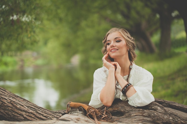 Foto mulher sorridente em vestido de estilo boho no lago ao ar livre