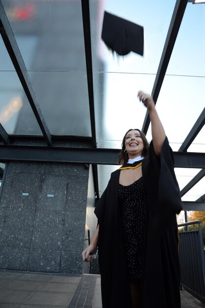 Foto mulher sorridente em vestido de formatura de pé ao ar livre