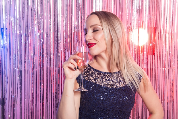 Mulher sorridente em vestido de noite com taça de champanhe