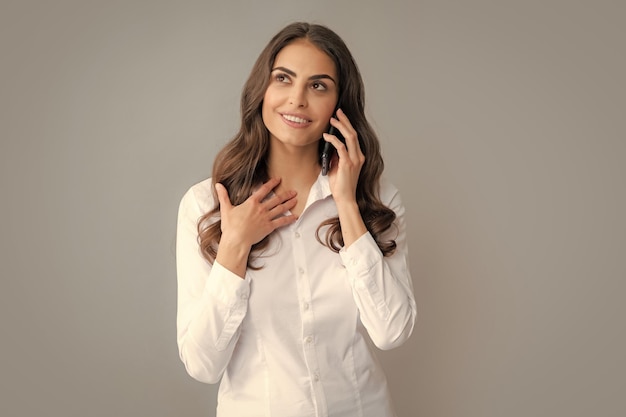 Foto mulher sorridente falando no celular isolado sobre fundo cinza menina com celular móvel