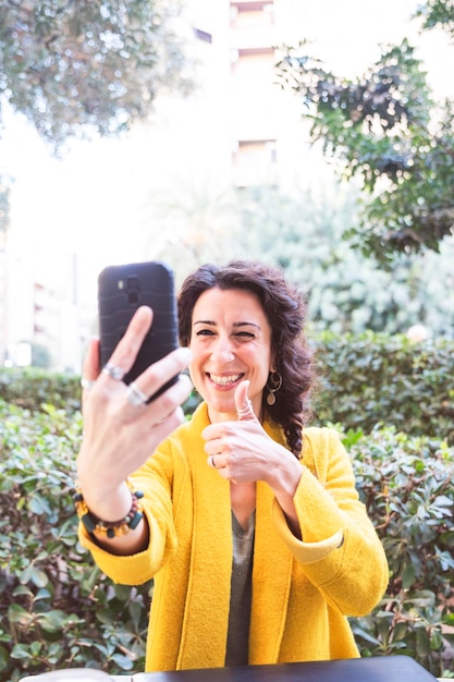 Mulher sorridente fazendo uma chamada de vídeo ao ar livre