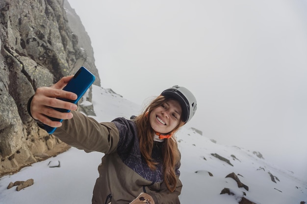 Mulher sorridente fazendo uma selfie na montanha