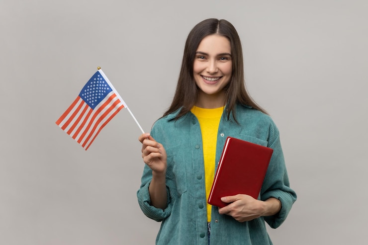 Foto mulher sorridente inteligente segurando em mãos livro e cursos de educação de bandeira americana no exterior