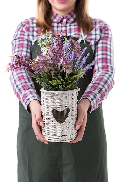 Foto mulher sorridente jardineiro profissional ou florista em avental segurando flores em um pote isolado no fundo branco