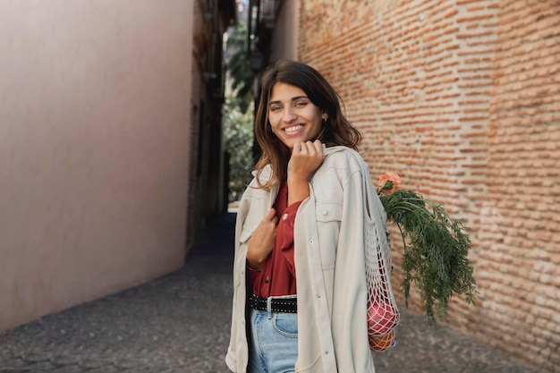 Mulher sorridente lá fora com sacolas de compras