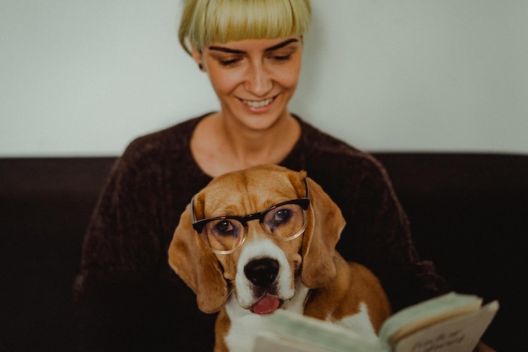 Foto mulher sorridente lendo um livro com o cão