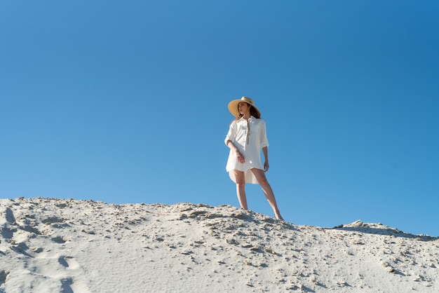 mulher sorridente magra muito atraente na praia ensolarada em roupa de tendência de moda estilo verão feliz, grátis