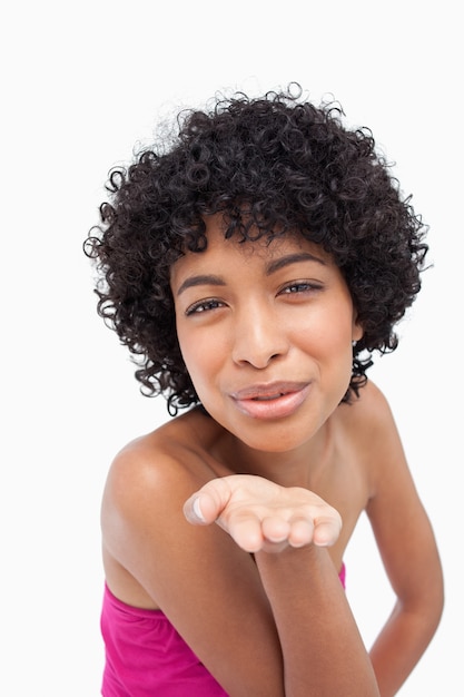 Mulher sorridente, mandando um beijo na frente da câmera