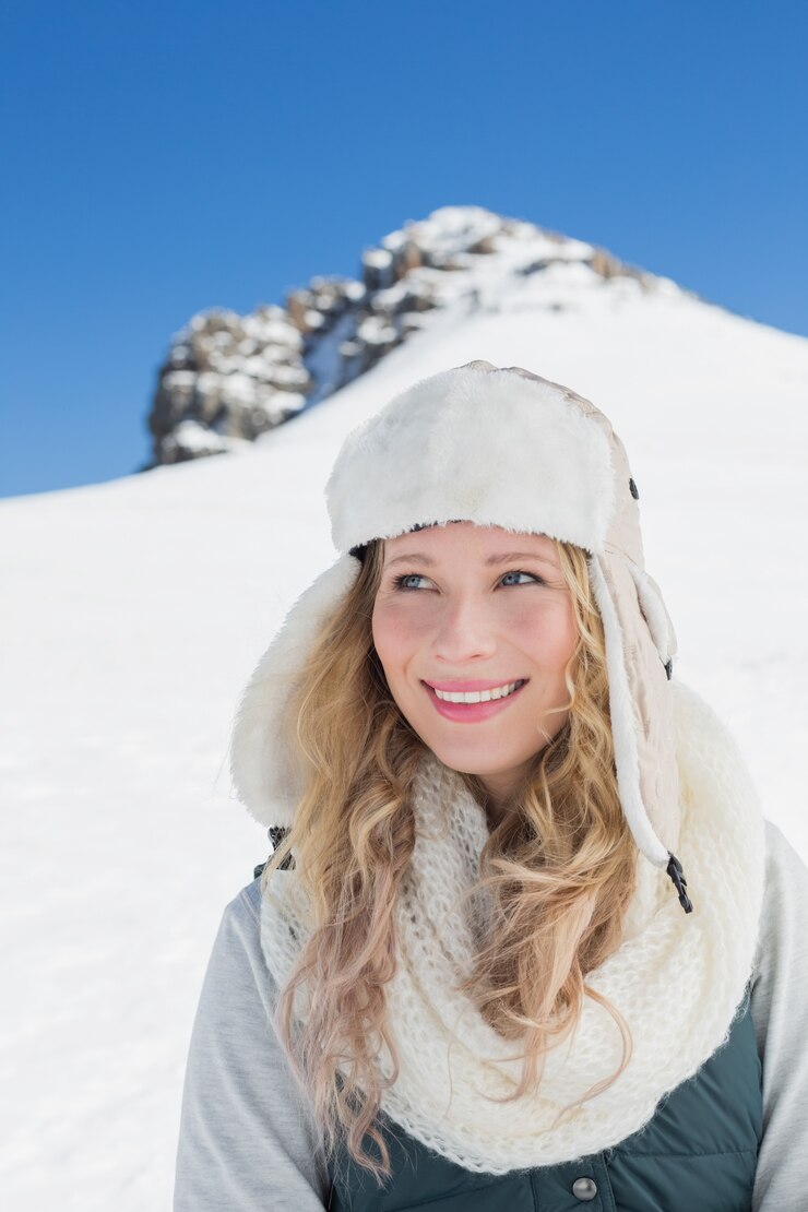 Foto mulher sorridente na frente do monte nevado e céu azul claro