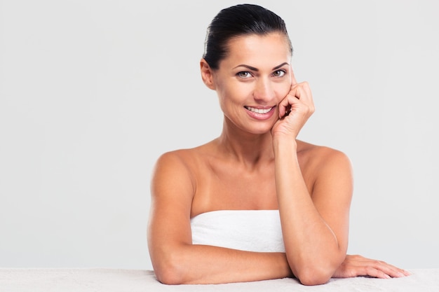 Mulher sorridente na toalha sentada à mesa