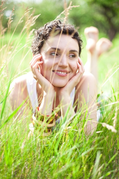 Mulher sorridente olhando para longe pelas plantas