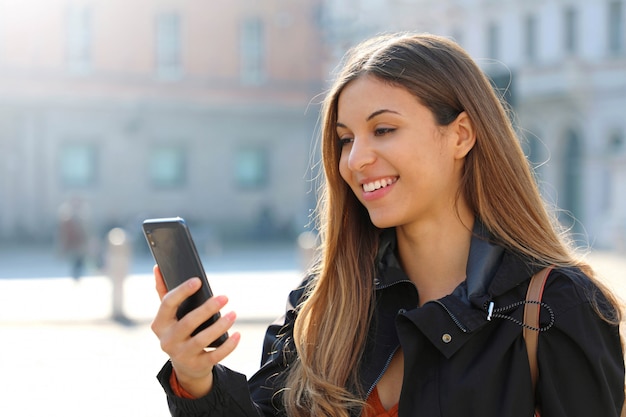 Mulher sorridente olhando para o telefone