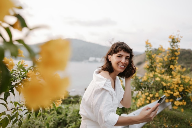 Mulher sorridente, olhe para a câmera em flores