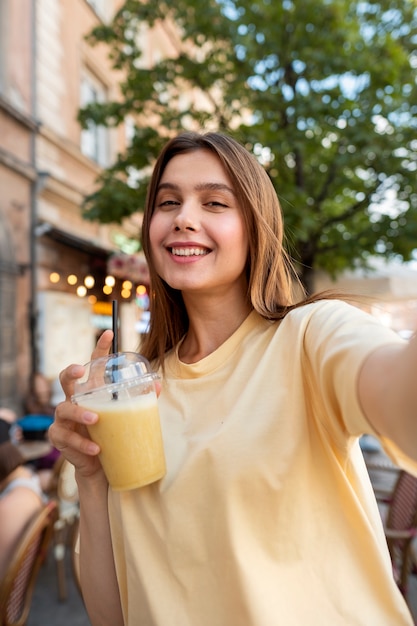 Foto mulher sorridente posando com bebida média de tiro