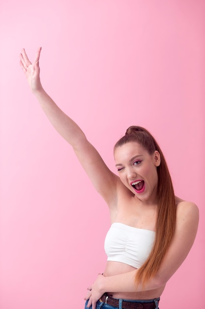 Foto mulher sorridente posando com plano médio de fundo rosa