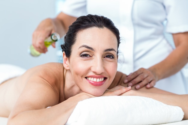 Mulher sorridente recebendo um tratamento de aromaterapia