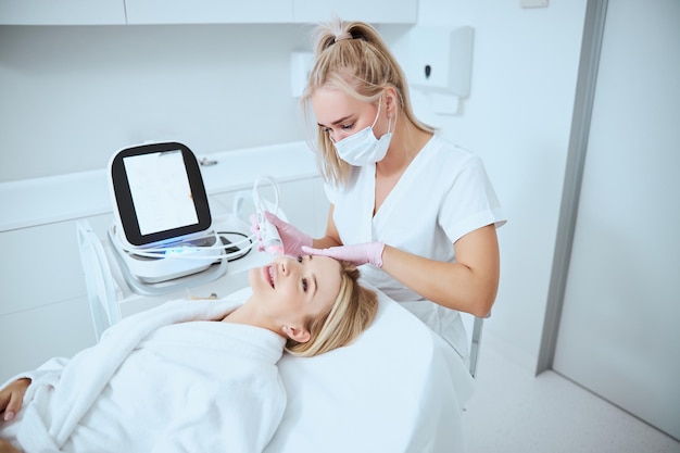 Mulher sorridente recebendo um tratamento de pele facial