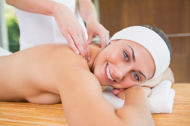 Mulher sorridente recebendo uma massagem nas costas