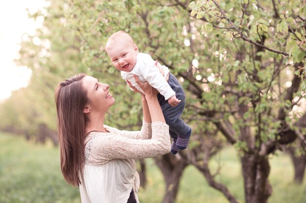 Mulher sorridente segurando um bebê ao ar livre