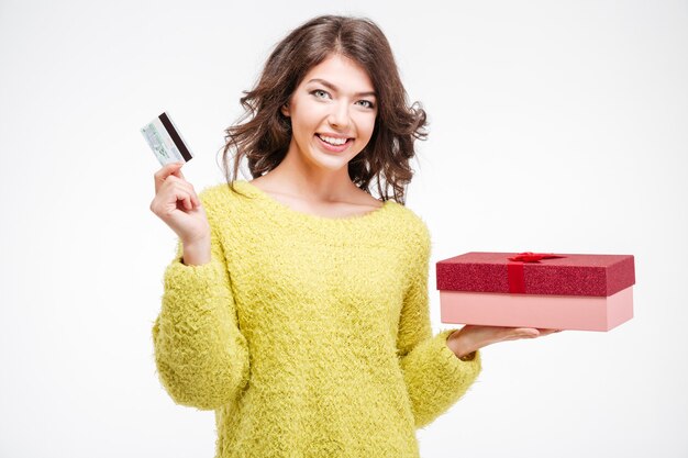 Mulher sorridente segurando um cartão do banco e uma caixa de presente isolados em um fundo branco