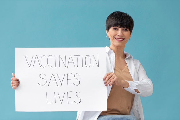 Foto mulher sorridente segurando um cartaz tiro médio