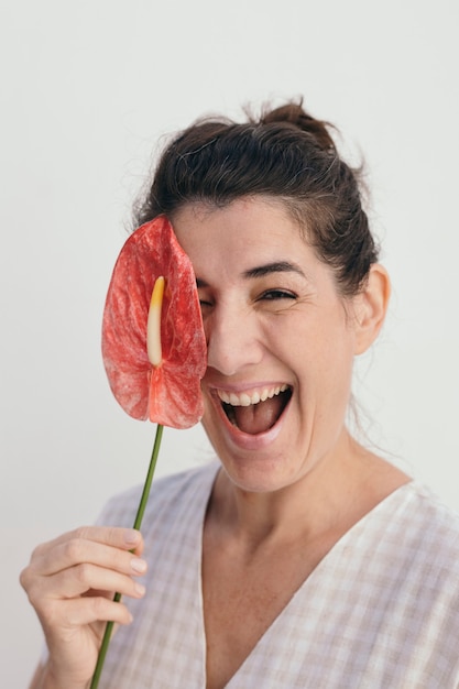 Foto mulher sorridente segurando uma flor em chamas