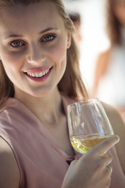 Mulher sorridente segurando uma taça de vinho no restaurante