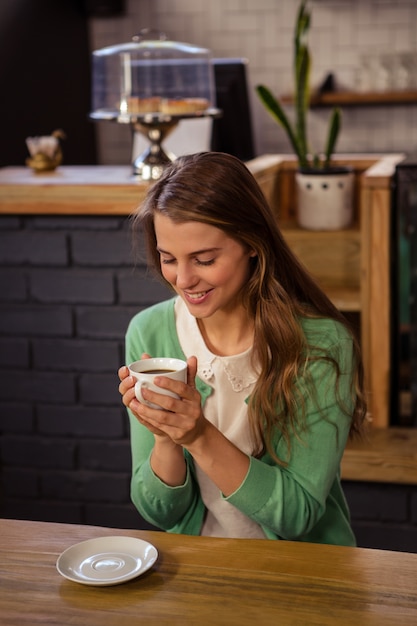 Mulher sorridente segurando uma xícara de café