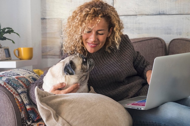 Mulher sorridente sentada com o cão em casa