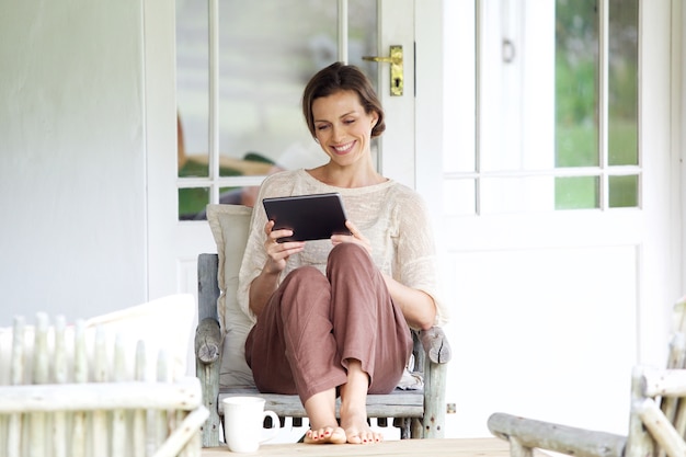 Mulher sorridente, sentando, com, tablete digital