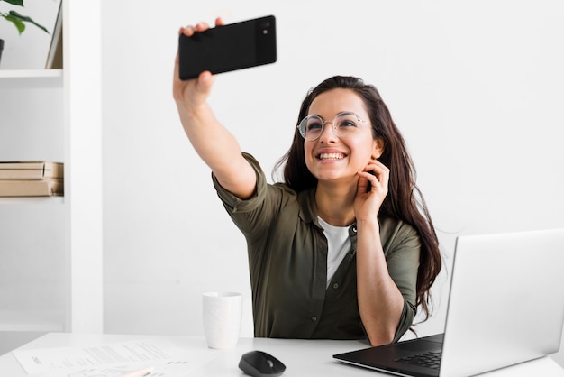 Foto mulher sorridente tomando selfie