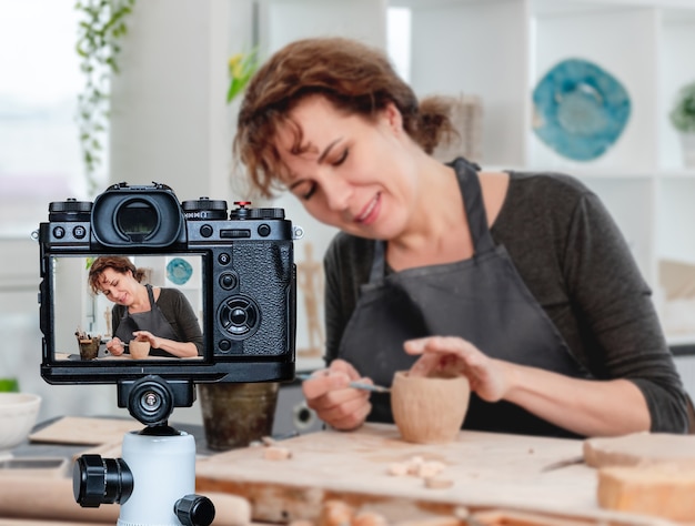 Mulher sorridente, trabalhando com o produto na oficina. profissão de blogueiro