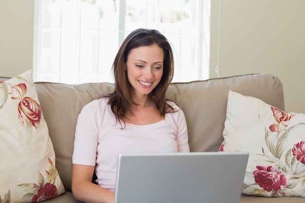 Mulher sorridente usando laptop em casa