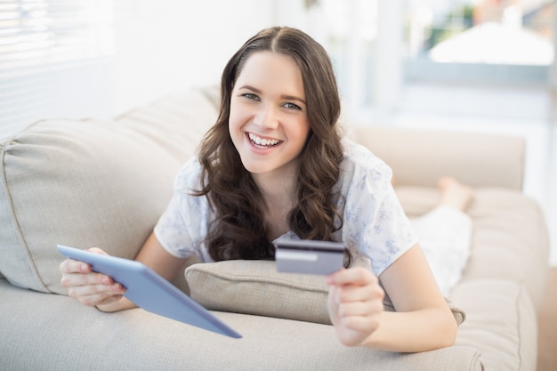 Mulher sorridente usando seu cartão de crédito para comprar on-line