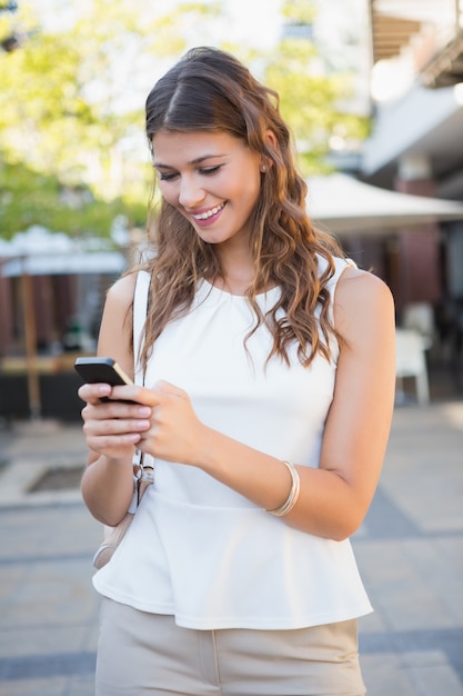 Mulher sorridente usando seu smartphone