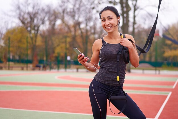 Foto mulher sorridente usando smartphone no parque
