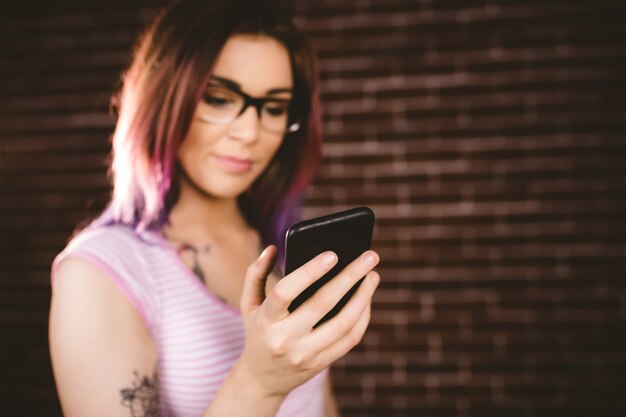 Mulher sorridente, usando telefone móvel