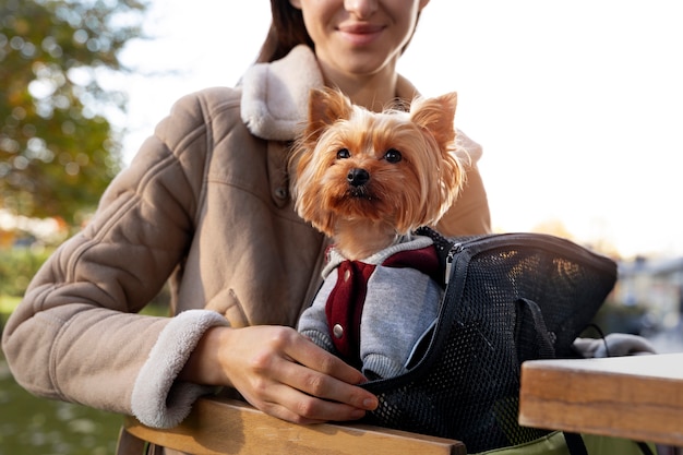 Foto mulher sorridente vista frontal com cachorro na bolsa