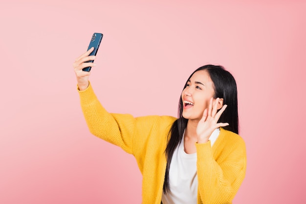 Mulher sorrindo animada fazendo videochamada de foto selfie no smartphone