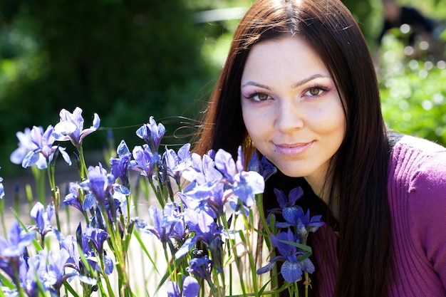 Mulher sorrindo ao ar livre com algumas flores