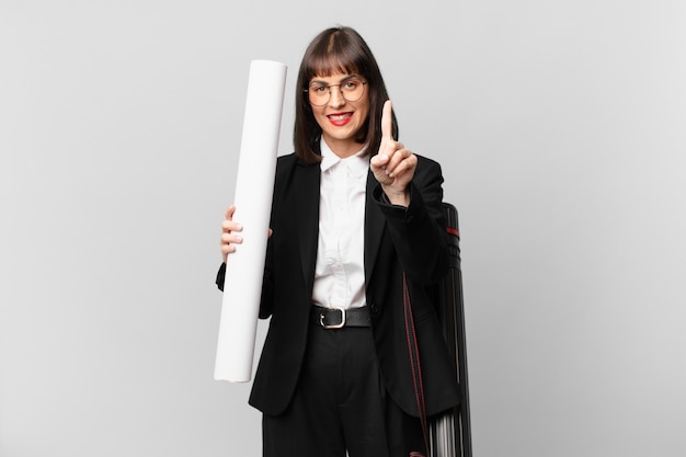 Mulher sorrindo com orgulho e confiança fazendo a pose número um triunfantemente, sentindo-se uma líder